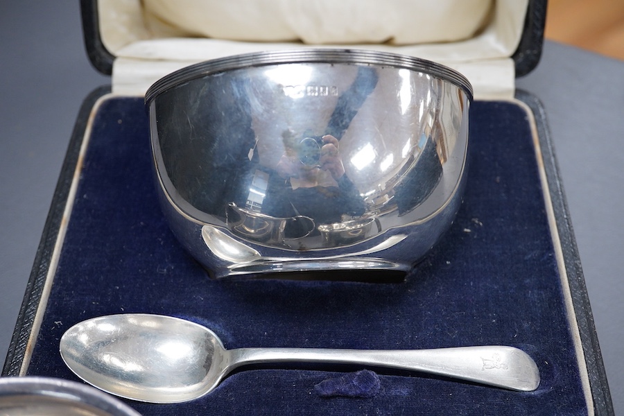 A George V Britannia standard silver mug, by Thomas Bradbury & Sons, Sheffield 1918, height 65mm, handle a.f., together with a 1930's silver porringer and a George V cased silver christening bowl and spoon, 13.2OZ.